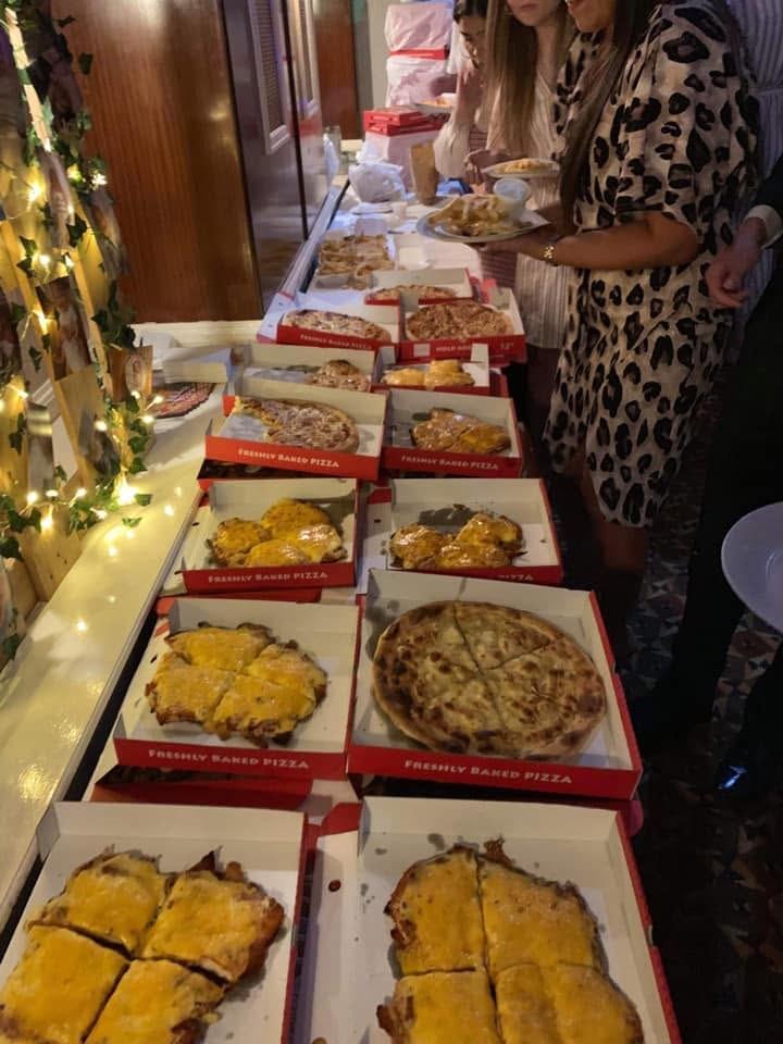 Open Express Pizzeria boxes of pizza and garlic bread laid out for a party